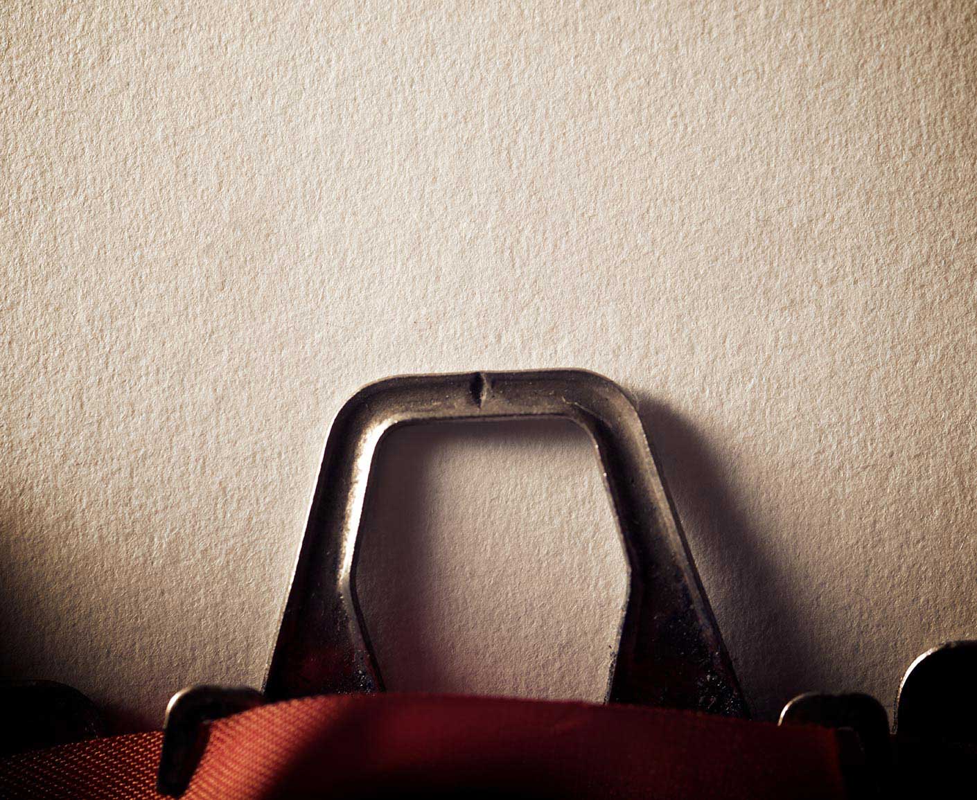 A close-up of a blank sheet of paper in a classic typewriter, as if waiting for the first word to be written.